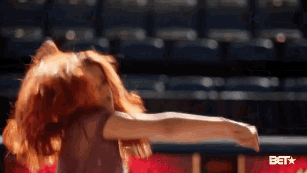 a woman with red hair is dancing in front of a bet star