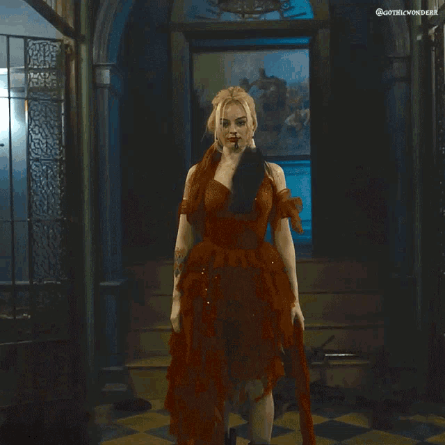 a woman in a red dress is standing in a hallway with a painting on the wall above her that says gothic vortex