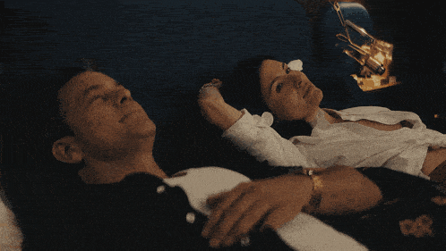 a man and a woman are laying on a couch