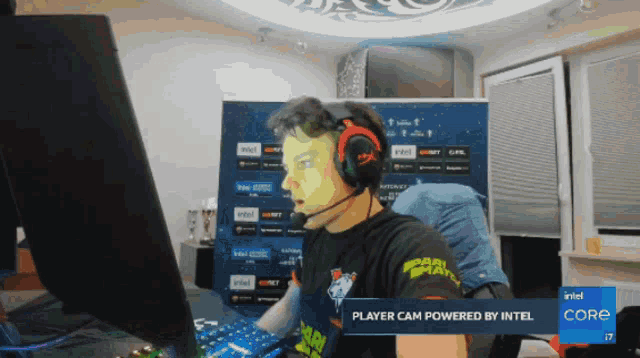 a man wearing headphones is playing a video game on a computer that is powered by intel