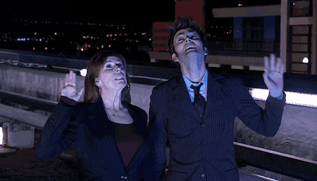 a man and a woman looking up at the sky at night