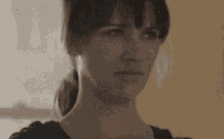 a close up of a woman 's face with a ponytail making a funny face .