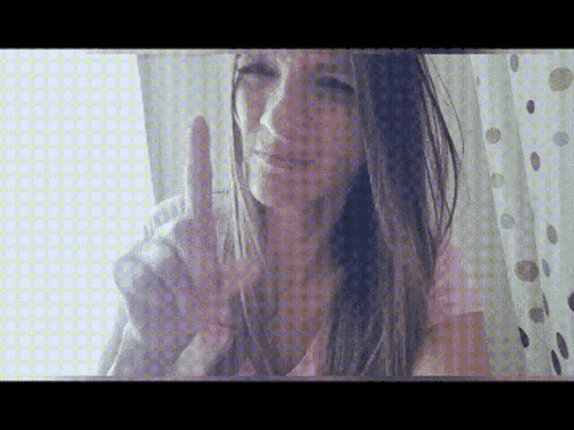 a woman giving a peace sign with her finger
