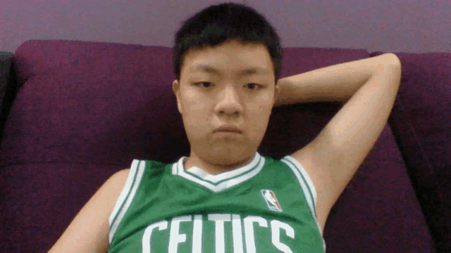 a young man wearing a green celtics jersey
