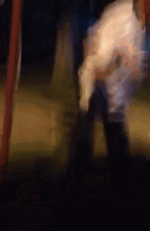 a blurry picture of a person standing on a swing at night
