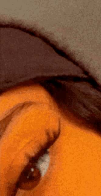 a close up of a person 's eye with a black hat on