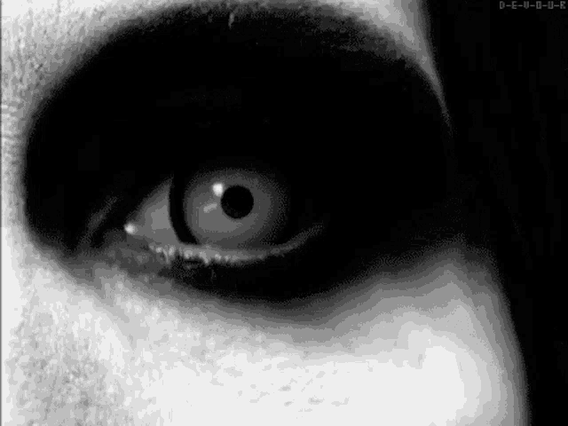 a black and white photo of a person 's eye with white contact lenses .