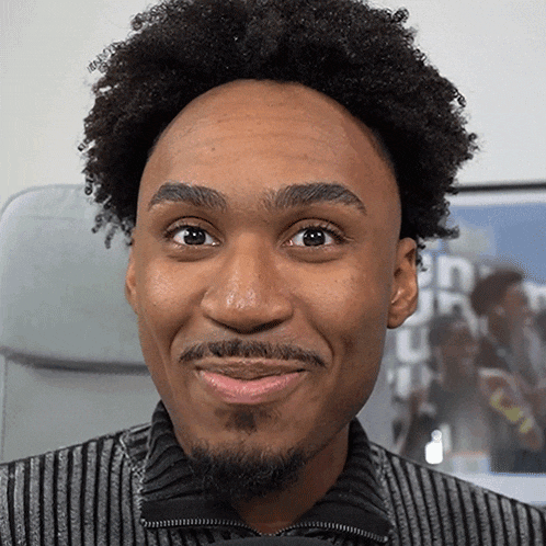 a man with a beard and curly hair is smiling