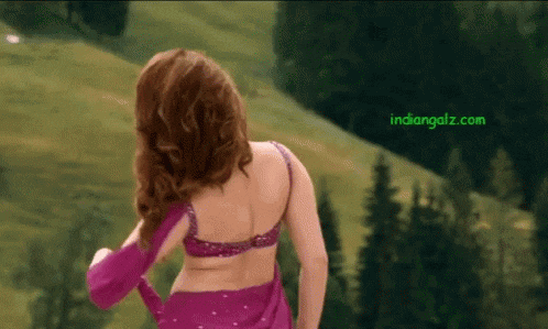 a woman in a purple top is standing in front of a green hill with the website indiangalz.com visible