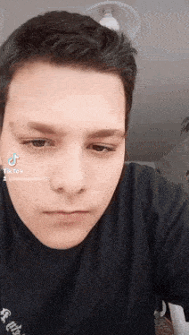 a close up of a young man 's face with a tik tok sticker on his face