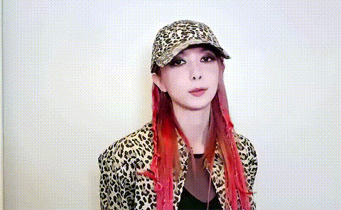 a woman with red hair is wearing a leopard print jacket and a baseball cap