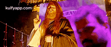 a man dressed as jesus is standing in front of a purple background