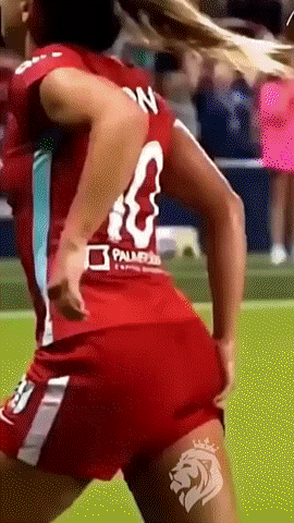 a woman in a red jersey and red shorts is playing soccer .