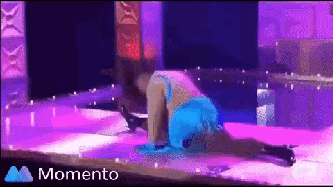 a woman in a blue dress is dancing on a stage with purple lights and the words momento on the bottom right