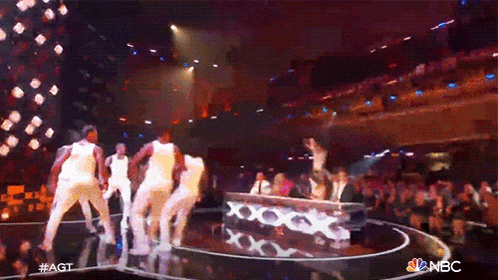 a group of people are dancing on a stage with a nbc logo in the corner