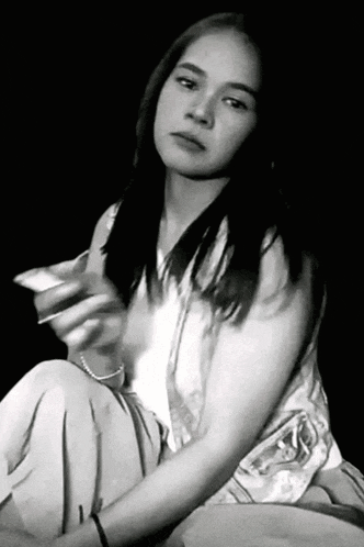 a black and white photo of a woman sitting down
