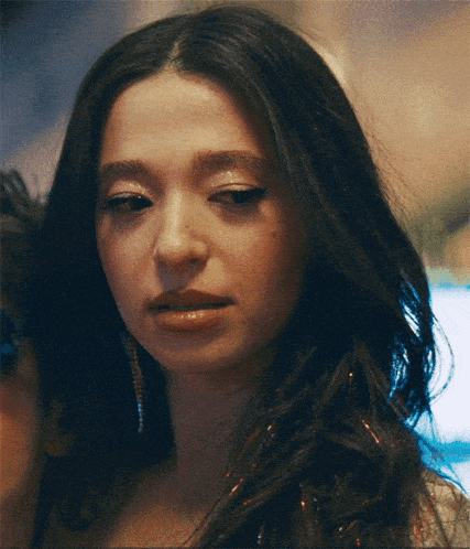a close up of a woman 's face with earrings on