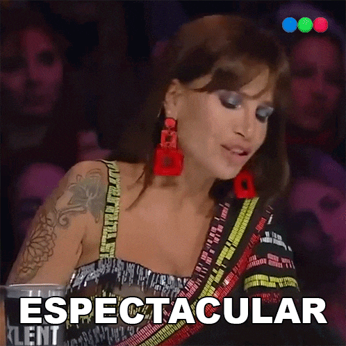a woman with a tattoo on her arm is wearing red earrings and the word espectacular is on the screen