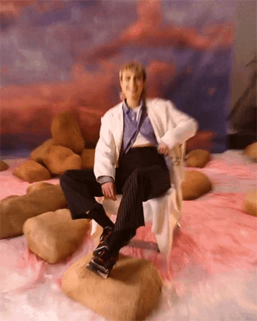 a woman is sitting on a rock on a bed