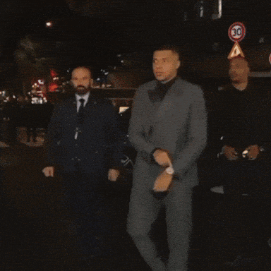 a man in a suit and tie is talking to another man in a suit