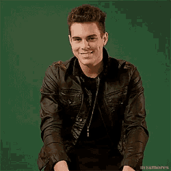 a young man wearing a leather jacket is smiling