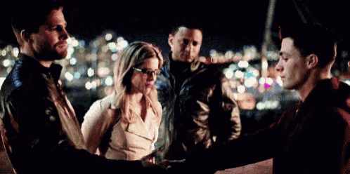 a group of people are shaking hands in a dark room with a city in the background