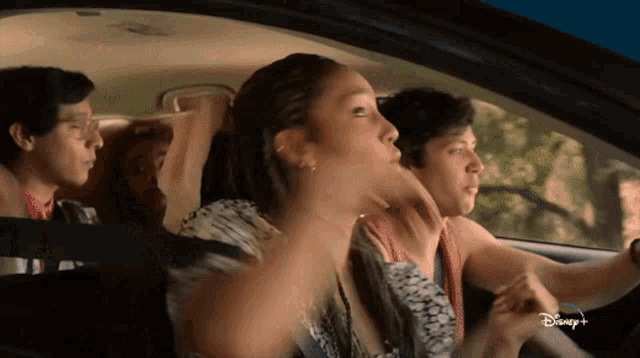 a group of people are sitting in a car with disney + written on the bottom