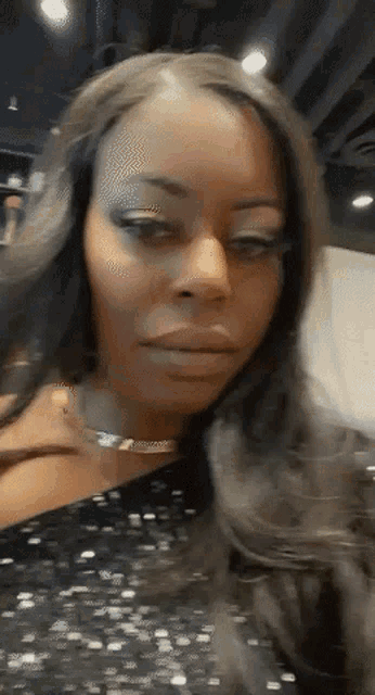 a woman with long hair is wearing a black dress