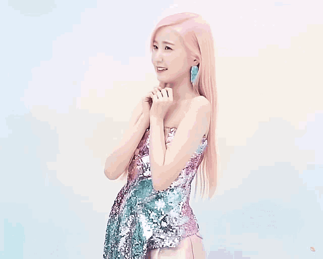 a woman with pink hair is wearing a sequined dress and earrings
