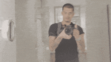 a man is smiling while holding a camera that says nikon on the lens