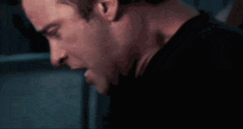a close up of a man 's face and neck in a dark room