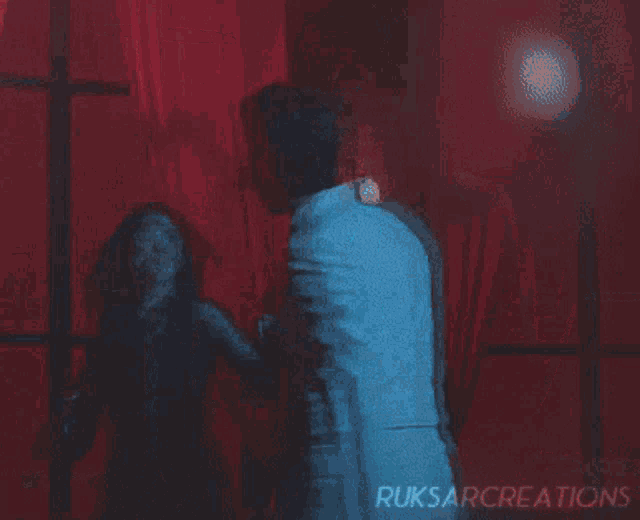 a man and a woman are standing in front of a red curtain with ruksarcreations on the bottom