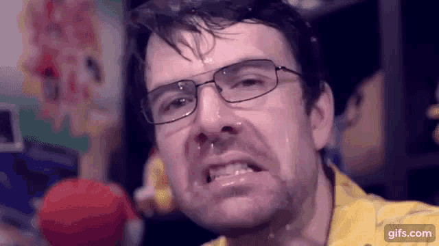 a man wearing glasses is making a funny face with his mouth open .