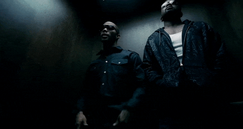 two men are standing next to each other in an elevator and one is wearing sunglasses