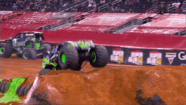 monster truck racing on a dirt track with super glue signs