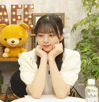 a young woman is sitting at a table with her hands on her face .