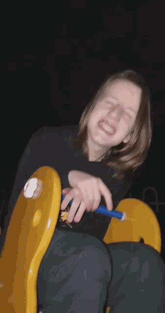 a person sitting on a yellow chair with a sticker on it