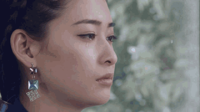 a close up of a woman 's face with a tear running down her face