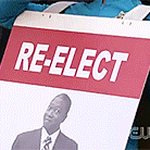 a sign that says re-elect with a picture of a man on it