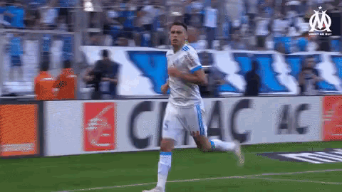 a soccer player is running on a soccer field in front of a banner that says ' ciac ac '
