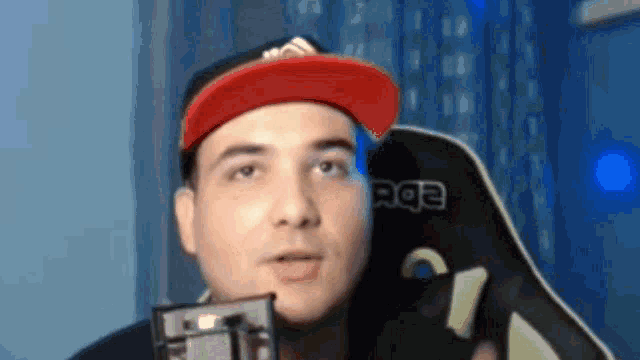 a man wearing a red hat and a black shirt with the letters ebc on it