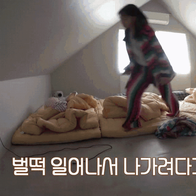 a woman in striped pajamas is jumping on a bed with korean writing