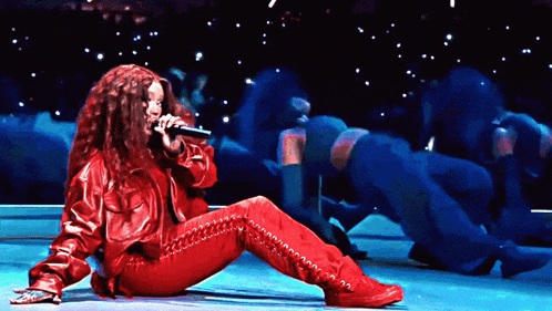 a woman is singing into a microphone on a stage