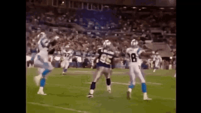 a group of football players are playing a game of football in a stadium .