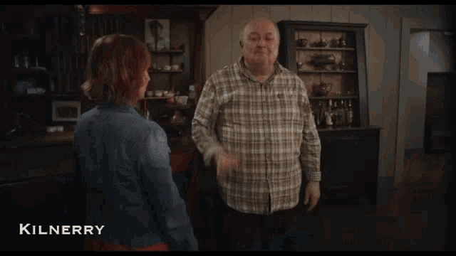a woman with red hair is being held by a man in a kilnerry advertisement
