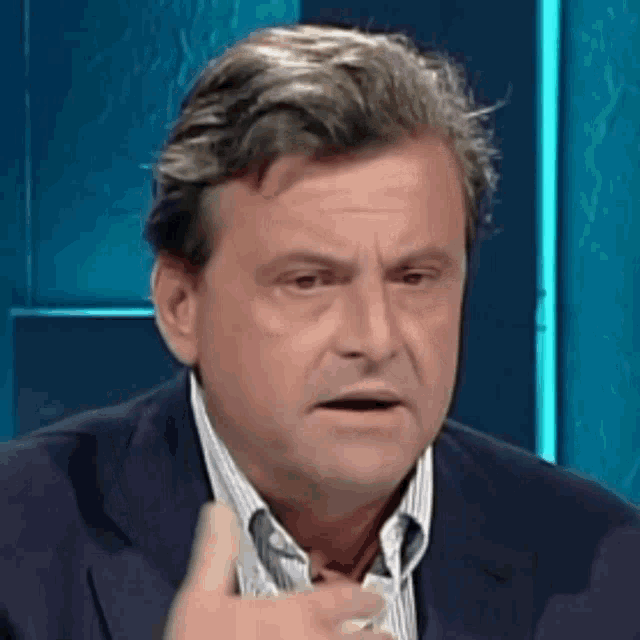 a man in a suit and striped shirt is making a face