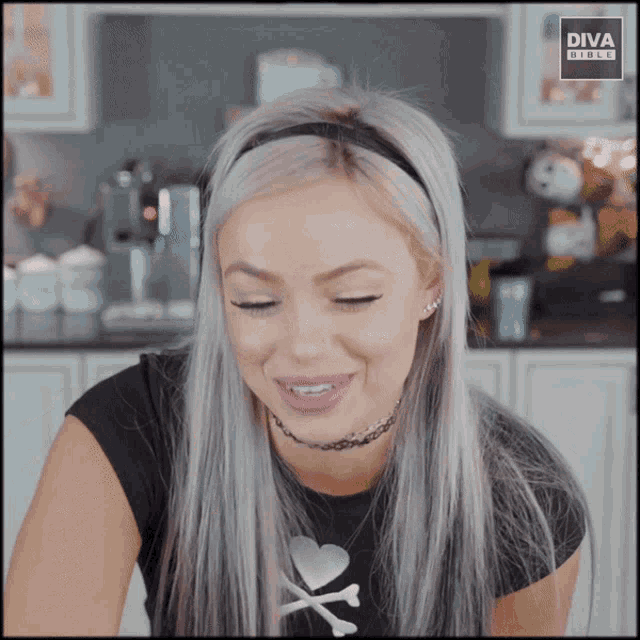 a woman wearing a black shirt with a choker and a headband with diva written on it