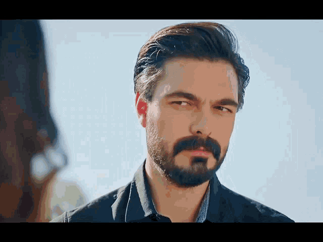 a man with a beard and mustache is looking at a woman