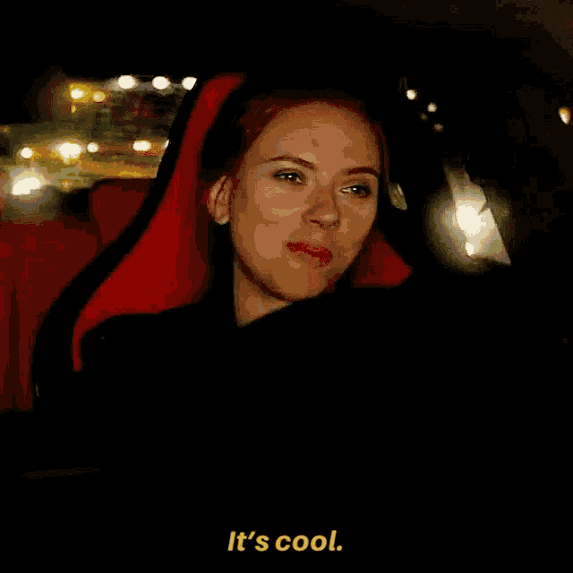 a woman is sitting in a car with a red seat and says it 's cool .