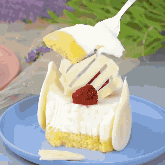a piece of cake with a strawberry on top is being eaten with a fork